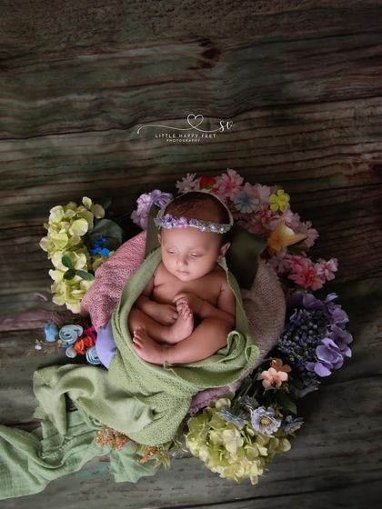 The eggshell pose, nestled in a bed of flowers. This pose is perfect for showing off how tiny and curled-up newborns are, and the flowers add a touch of natural beauty.