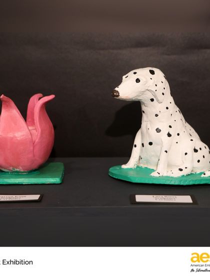 Detailed ceramic sculptures of a dalmatian and a lotus flower from the MS Art Exhibition. Our students explore a variety of mediums, including pottery and sculpture, to bring their creative visions to life.