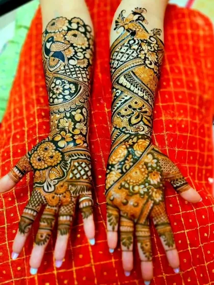 This vibrant, full-arm design uses a mix of diagonal patterns and floral motifs. The peacocks are intricately detailed, and the overall composition is both traditional and dynamic.