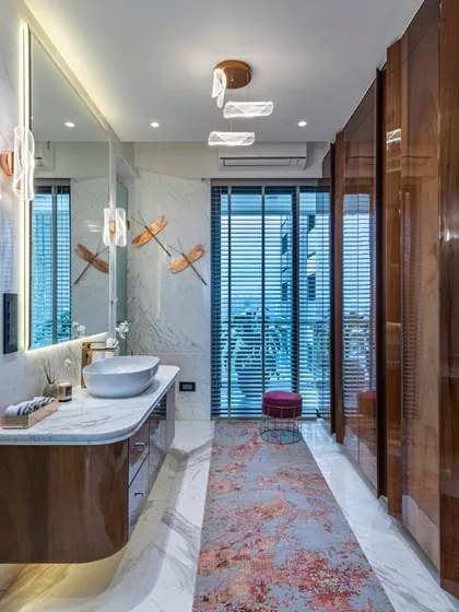 A full view of the spacious and elegant bathroom in the Filigree House. The long vanity, large mirror, and walk-in shower create a sense of luxury and openness, with a view to the balcony beyond.