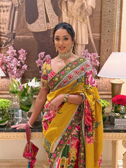 A full-length shot in a luxurious interior, highlighting the elegance of the client and her designer outfit.