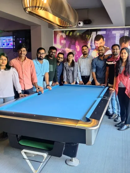 A corporate team gathers around the pool table. We offer a variety of games like 8-ball pool to ensure there's something for everyone during a team outing.