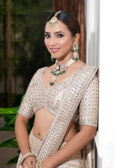 Blending tradition with sophistication in this ivory lehenga look. We opted for subtle smokey eyes and flushed skin to let her emerald jewelry shine.