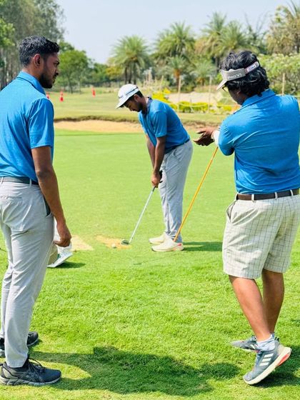 Coach Hari (right) uses alignment sticks to provide precise technical feedback. He believes in structured sessions that help players understand the 'why' behind their training.