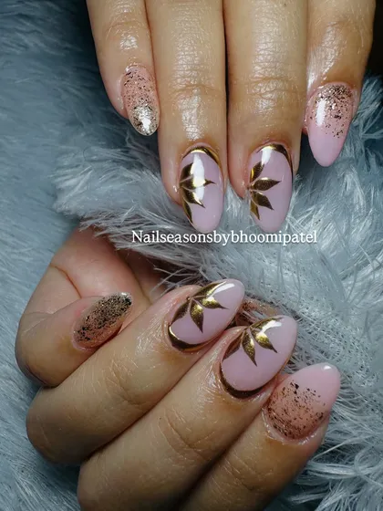 My most viral nail art design. It features a soft pink base with gold chrome tips, gold glitter, and hand-painted gold leaf accents.
