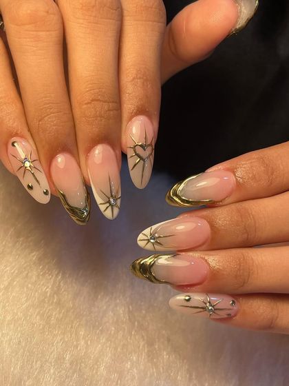 Celestial elegance at its finest. This set features a soft ombre base with delicate gold chrome tips, accented with 3D starbursts and heart details for a touch of cosmic glamour.