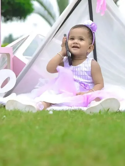 A playful moment during an outdoor shoot, where the birthday girl pretends to be on a call. Our setups include space and props for capturing these spontaneous, cute moments.
