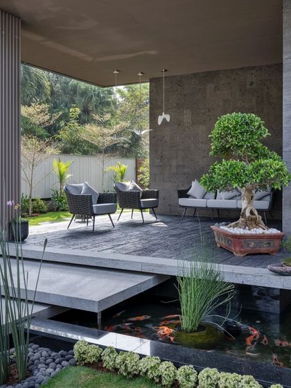 A serene outdoor deck overlooks a koi pond, creating a zen-like atmosphere for this modern Mysuru home.