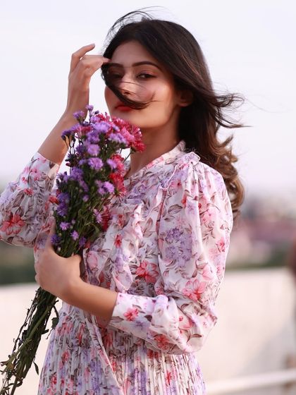 A breezy and beautiful portrait. The wind in her hair and the soft, open-air background create a feeling of freedom and natural elegance.