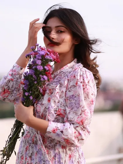 A breezy and beautiful portrait. The wind in her hair and the soft, open-air background create a feeling of freedom and natural elegance.