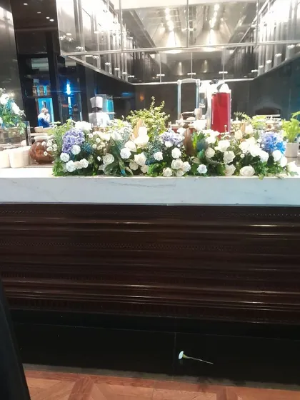 We also provide elegant floral arrangements for event spaces, like this beautiful display of white and blue hydrangeas on a buffet counter, adding a touch of class to the celebration.