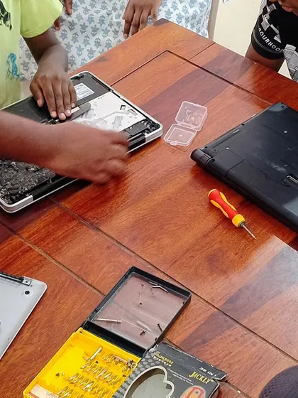 Kids learning to disassemble and repair laptops at a summer camp. This hands on experience is invaluable for understanding how technology works.