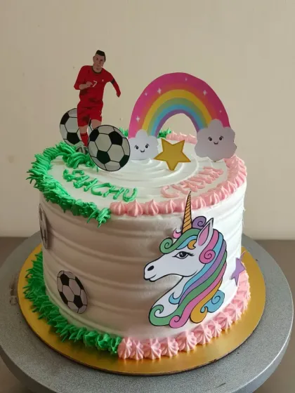 A fun cake for twins with different interests. One half is dedicated to unicorns and rainbows, while the other half is all about football.