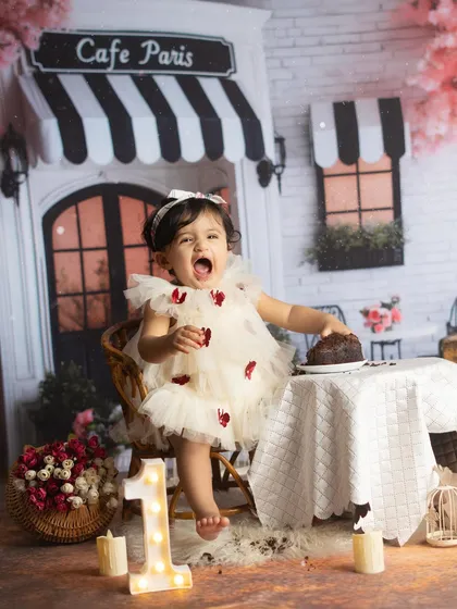 A moment of pure excitement. This little one can't wait to dig into her first birthday cake.