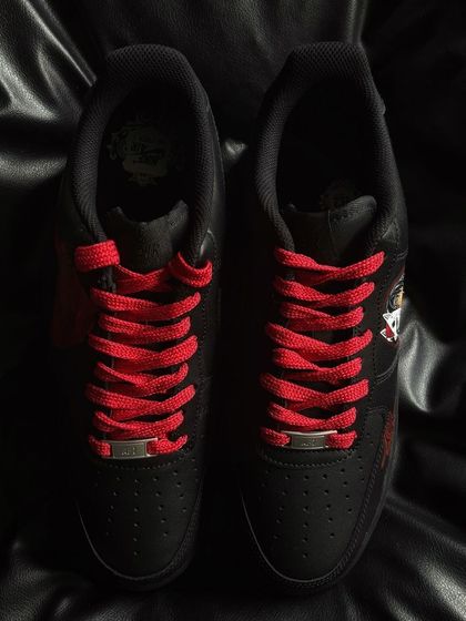 A top-down view of the black Itachi custom sneakers with contrasting red laces.