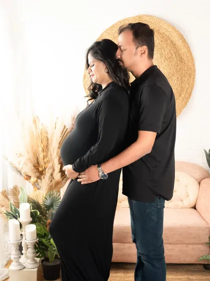 A gentle embrace from behind. The husband's hands cradle the baby bump, showing his love and support in a simple, beautiful pose.