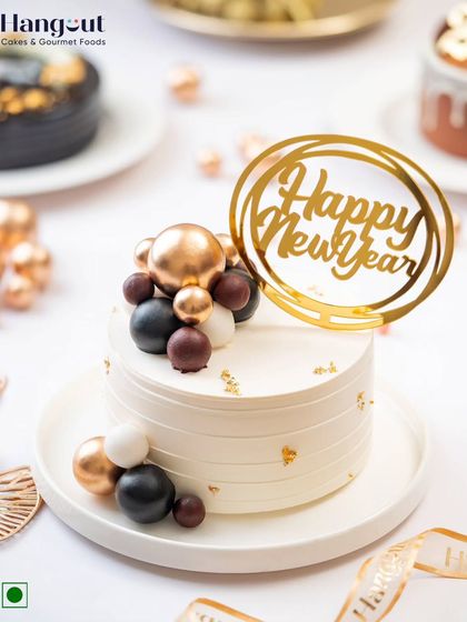 This elegant New Year bento cake is perfect for sharing the joy of new beginnings. It's decorated with festive chocolate spheres and a "Happy New Year" topper.
