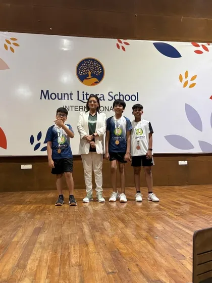 A group of our young winners and participants on stage at the IB Interschool Tournament prize distribution ceremony.
