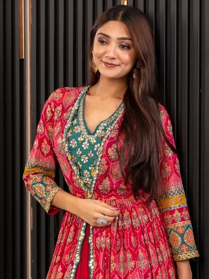 A close-up of this vibrant pink and green Indo-Western outfit. The printed jacket over a green crop top and red skirt is a celebration of color and style.
