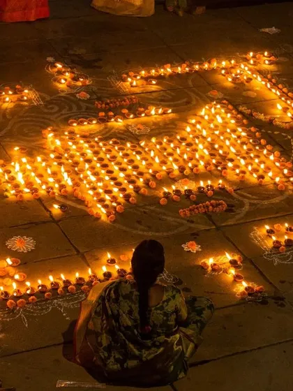 A beautiful rangoli made of hundreds of lit diyas on the ghats. This image showcases the artistic and community effort that goes into the festival.