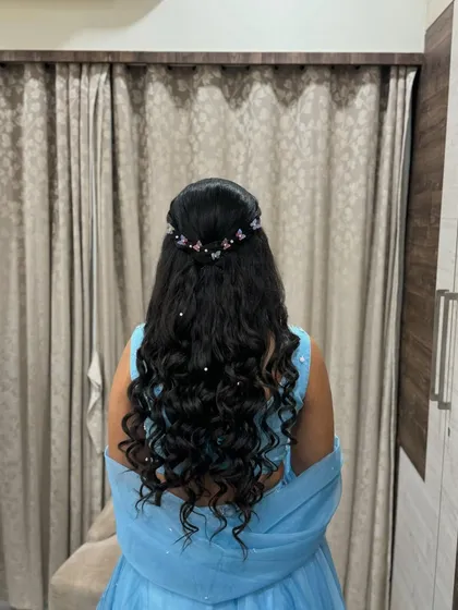 A whimsical hairstyle with butterfly clips and a custom name pin, adding a personal and playful touch.