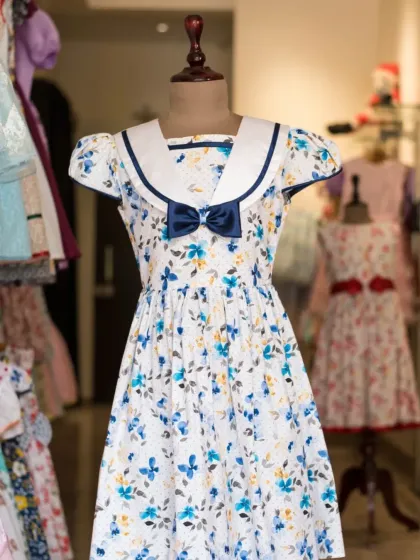 A classic sailor dress with a twist. The blue floral print gives this timeless silhouette a fresh, modern feel, perfect for a stylish little girl.
