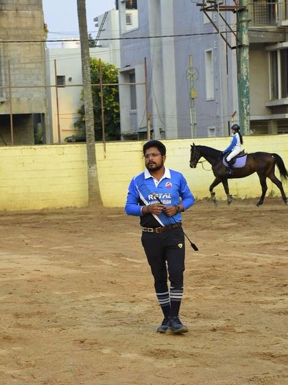 A photo of our coach during a training camp, with a rider in the background. Our trainers are always on the ground, providing real-time feedback and instruction.