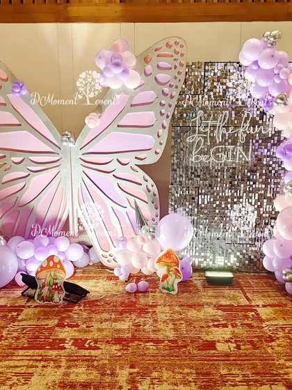 Another angle of the butterfly and sequin wall photo booth. This view shows the full balloon garland and the playful mushroom cutouts at the base, adding to the enchanted forest feel.