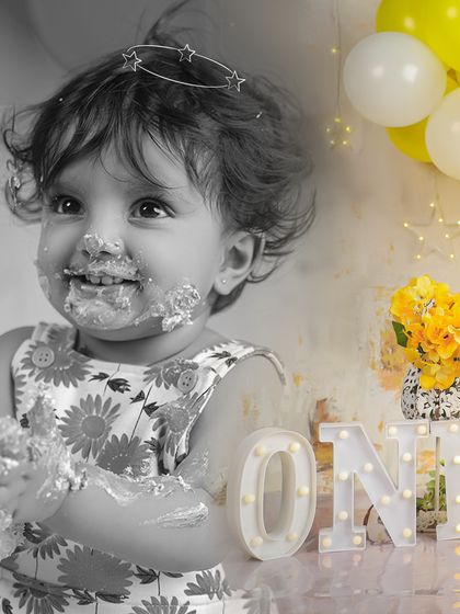 A beautiful black and white photo with a pop of color on the flowers. This artistic edit highlights the baby's messy, happy face.