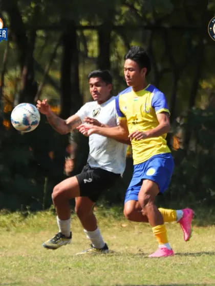 Battling for control. Two players compete for the ball, highlighting the intensity of a midfield tussle.