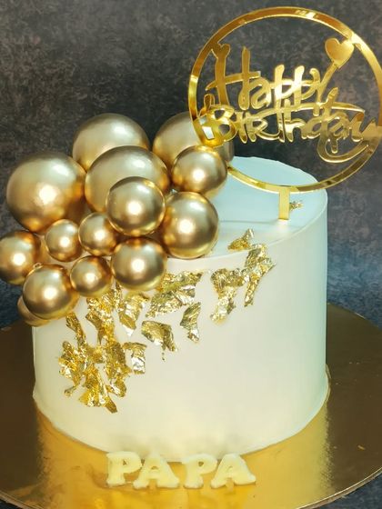 A classy cake for "Papa". This choco-vanilla cake is decorated with golden spheres and gold leaf for a luxurious feel.