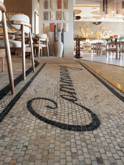 Detail is everything. This custom mosaic floor at One 8 Commune was handcrafted by my artisans, piece by piece. The design, which spells out "Communing," serves as a signature art piece that grounds the space and immediately communicates the restaurant's brand and welcoming vibe. It’s a perfect example of how flooring can be foundational art.