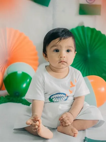 A thoughtful expression from our little patriot. The setup with orange, white, and green props creates a festive atmosphere.