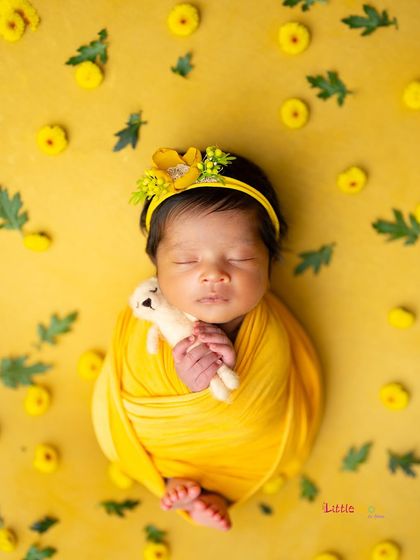 A sweet moment with a tiny teddy bear, all bundled up in a sunny yellow wrap. These little details make the photos even more precious.