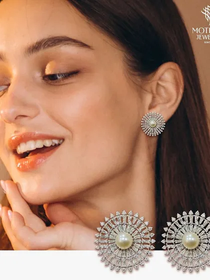 A model smiles while wearing a pair of our classic pearl and diamond sunburst stud earrings, a design that is both radiant and timeless.