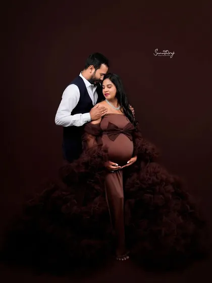 A loving couple portrait in a rich brown gown. The husband's gentle touch and their close pose convey a sense of warmth, protection, and deep affection.