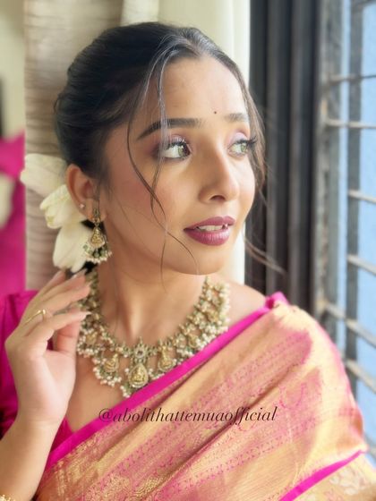 A side profile of the soft glam look, highlighting the flawless skin and the elegant, wispy hairstyle.