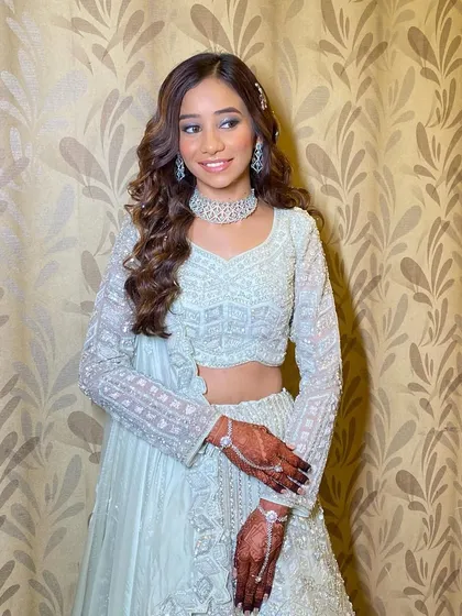 A neutral yet glamorous look for this stunner. I created a glass skin finish with glossy lips and soft, shimmery eyes to complement her mint green lehenga.