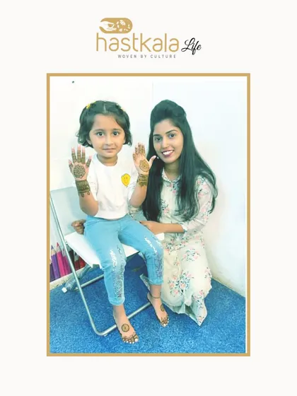 An image from my feature, where I'm applying mehendi to a little girl. I believe in making everyone, no matter their age, feel special with my art.