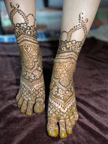 An elegant foot design featuring a heart-shaped negative space at the ankle. The rest of the foot is covered in a mix of paisley and floral patterns for a soft, romantic feel.