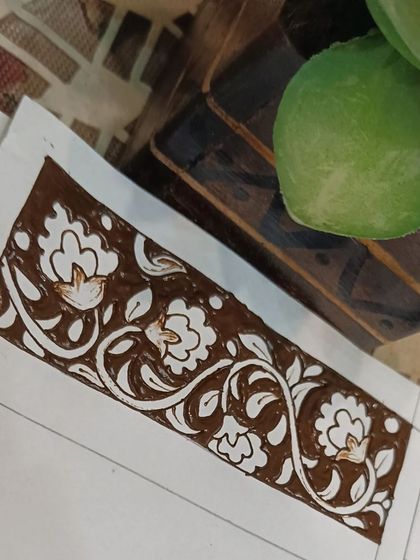 A completed floral vine border on a practice sheet, using the negative space technique for a bold look.