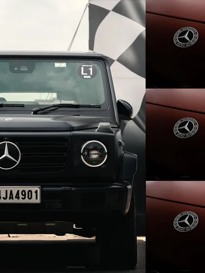 A creative composition featuring the front of a black Mercedes G-Wagon next to the brand's logo. This shot plays with branding and the vehicle's iconic, powerful stance.