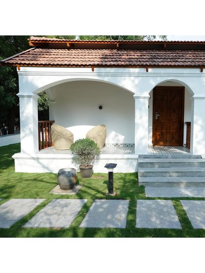 A close-up of one of the villa's entryways. You can see the details of the arched veranda, the patterned floor tiles, and the simple, elegant wooden door, all coming together to create a charming entrance.