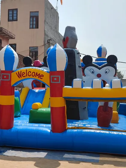 A large "Fun City" bouncy with a Mickey Mouse theme. This model includes a climbing wall, slides, and a spacious jumping area, perfect for large events.