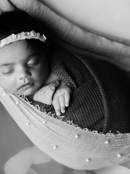 Another beautiful black and white shot, this time of a newborn sleeping in a gentle hammock, creating a sense of peace and security.