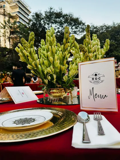We had the distinct pleasure of serving Mr. Dhariwal, the chairperson of the Manikchand group, and his family. This elegant table setting, with its rich red and gold palette, was designed for their prestigious event.