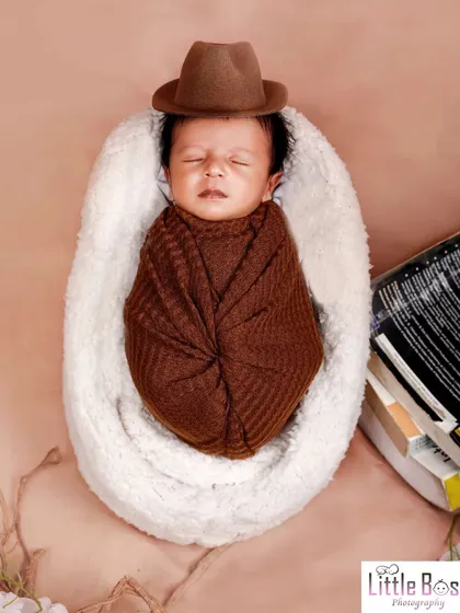 This little reader, with a stylish brown fedora, is sleeping soundly on a stack of books. A clever theme for a family of book lovers.