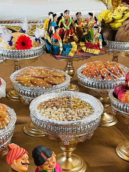 A close-up of my signature plate decorations, showing a variety of traditional sweets and dry fruits. The doll scene in the background adds to the festive atmosphere.