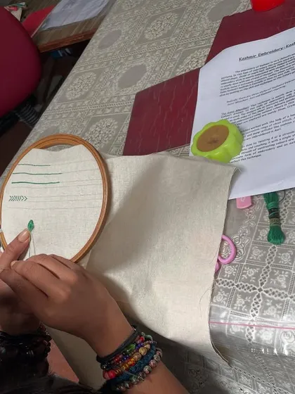 A student begins her project, with pattern sheets and materials laid out. The atmosphere in the workshop is one of focused creativity and enthusiastic learning.