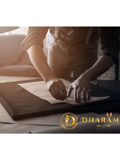 A tailor meticulously working on a pattern. This is the foundational step to ensure the garment is crafted to the client's exact specifications.